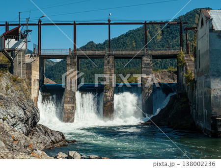 Hydro power plant near a river amidst mountains under a clear blue sky during daytime Hydro power plant near a river amidst mountains under a clear blue sky during daytime 138002236
