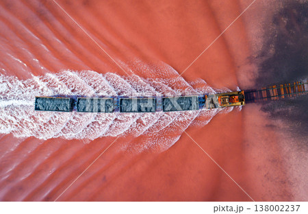 Aerial view of an old train rides on the railway laid in the water through the salt lake. Salt mining in Lake Burlin. Altai. Bursol. Aerial view of an old train rides on the railway laid in the water through the salt lake. Salt mining in Lake Burlin. Altai. Bursol. 138002237