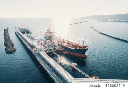 Aerial view of a large oil tanker docked at a pier in the port in process of loading. 138002249