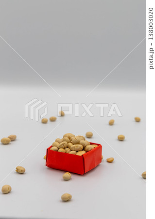 赤い折り紙の箱に入った大豆と散らばる豆 節分の豆まきイメージ 白背景 138003020
