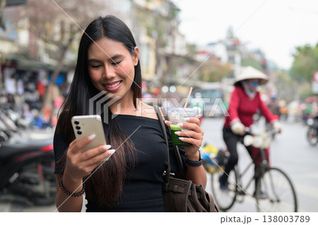 Asian Woman Using Smartphone with Iced Matcha in Hanoi Asian Woman Using Smartphone with Iced Matcha in Hanoi 138003789