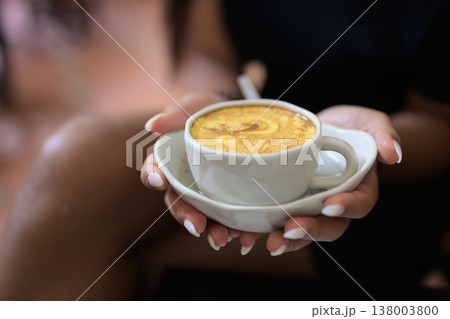 Hot Vietnamese Egg Coffee in Cup Held by Young Asian Woman 138003800