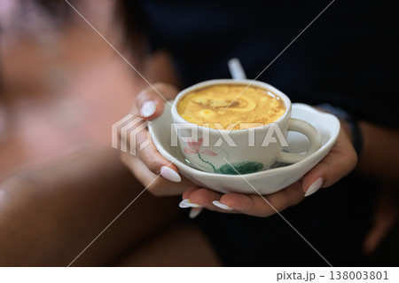 Hot Vietnamese Egg Coffee in Cup Held by Young Asian Woman 138003801