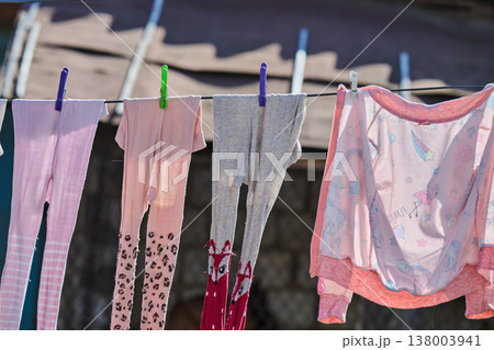 washed children's clothes are drying 138003941