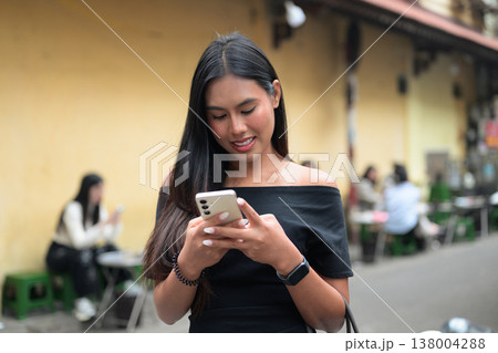 Thai Woman Using Smartphone on Hanoi Street 138004288