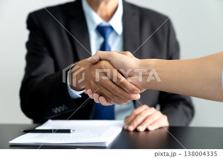 Legal counsel lawyer and client shaking hands to congratulate 138004335
