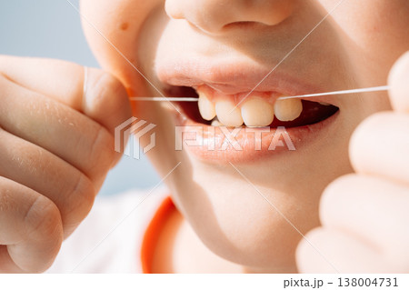 Close up child flossing teeth with dental floss string, oral hygiene and prevention concept Close up child flossing teeth with dental floss string, oral hygiene and prevention concept 138004731