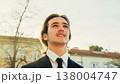 Portrait of the Handsome White man with brown hair,  in the city, on the summer. Young smiling businessman looking up, outdoors. Young stylish man in business suit is on the street.	People lifestyle 138004747