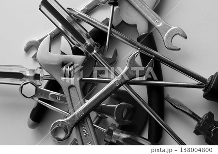 Variety scattered hand tools on a white shelf. Monochrome stock photo for repairing backgrounds 138004800