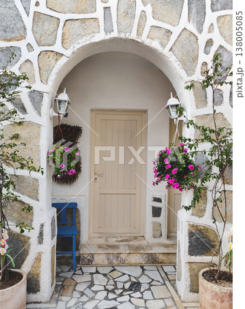 Traditional stone house entrance with a white arch and pink flowers in Bodrum, Turkey Traditional stone house entrance with a white arch and pink flowers in Bodrum, Turkey 138005085