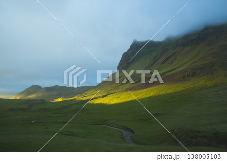 Winding mountain stream in a lush green valley in Iceland 138005103