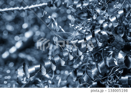 Close-up of a pile of blue-toned metal spiral chips and swarf from a high-precision CNC turning process. Close-up of a pile of blue-toned metal spiral chips and swarf from a high-precision CNC turning process. 138005198