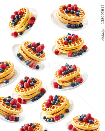 Stacked waffles topped with fresh berries in repeating layout isolated on white background, expressing a breakfast concept 138005615