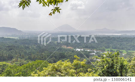 Panoramic Tropical Forest Landscape with Distant Mountains and River Under Overcast Sky, Lush Green Canopy View from Above. Sri Lanka island in Asia. Panoramic Tropical Forest Landscape with Distant Mountains and River Under Overcast Sky, Lush Green Canopy View from Above. Sri Lanka island in Asia. 138006141