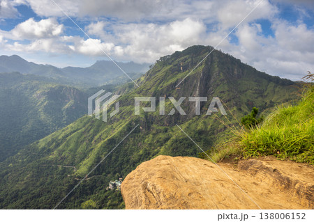 Ella rock mountain, view from Little Adam's Peak in Sri Lanka. Breathtaking panoramic view of lush green mountains under a dynamic sky with scattered clouds 138006152
