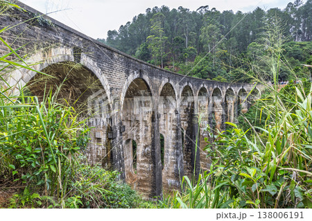 Nine Arch Bridge near Ella town in Sri Lanka. Historical stone arch bridge spanning a lush green valley with dense forest under a bright sky, a testament to engineering 138006191