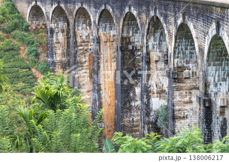 Nine Arch Bridge near Ella town in Sri Lanka. Ancient Stone Arch Bridge Amidst Lush Green Tropical Foliage on a Hillside, a Historical Architectural Wonder Nine Arch Bridge near Ella town in Sri Lanka. Ancient Stone Arch Bridge Amidst Lush Green Tropical Foliage on a Hillside, a Historical Architectural Wonder 138006217
