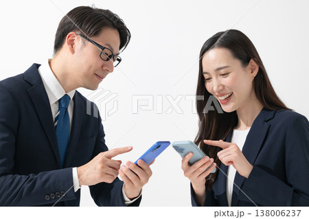 スマホを持つビジネスマンとビジネスウーマン スマホを持つビジネスマンとビジネスウーマン 138006237