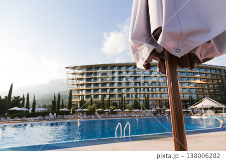 Outdoor Pool And Landscaped Surroundings. Vacation Setting With Sunlit Balcony And Lush Landscaping Outdoor Pool And Landscaped Surroundings. Vacation Setting With Sunlit Balcony And Lush Landscaping 138006282