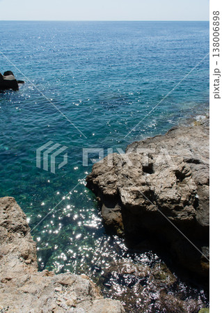 明るい日差しの下の透き通った青い海と岩場 地中海に浮かぶフランス領のコルシカ島にて 明るい日差しの下の透き通った青い海と岩場 地中海に浮かぶフランス領のコルシカ島にて 138006898