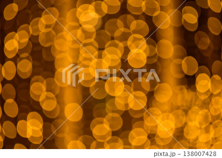 Abstract bokeh effect of the gold, yellow lights on black background. City street light decorations. Rows of LED gold colored light spots with black background. Abstract bokeh effect of the gold, yellow lights on black background. City street light decorations. Rows of LED gold colored light spots with black background. 138007428