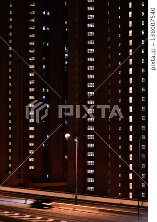 Close-up of the street light at night with buildings in the background. Cityscape and street scene at night with dark background. Close-up of the street light at night with buildings in the background. Cityscape and street scene at night with dark background. 138007540