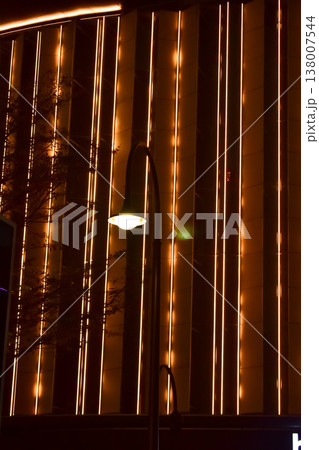 Close-up of the street light at night with buildings in the background. Cityscape and street scene at night with dark background. Close-up of the street light at night with buildings in the background. Cityscape and street scene at night with dark background. 138007544