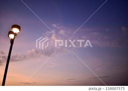 Close-up of the streetlight at the sunset, City light in the street with sky background. Cityscape and downtown scene. Close-up of the streetlight at the sunset, City light in the street with sky background. Cityscape and downtown scene. 138007575