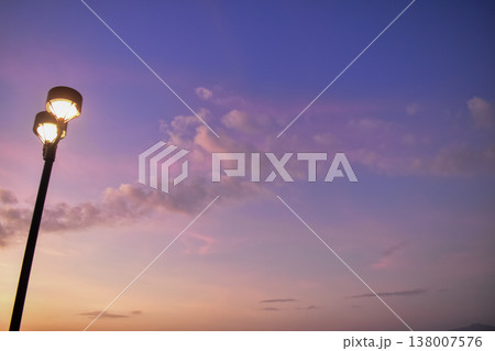 Close-up of the streetlight at the sunset, City light in the street with sky background. Cityscape and downtown scene. Close-up of the streetlight at the sunset, City light in the street with sky background. Cityscape and downtown scene. 138007576