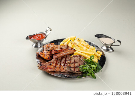 Grilled meat platter with fries and sauces Grilled meat platter with fries and sauces 138008941