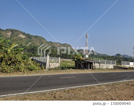 Scenic Countryside Road With Hills, Vegetation, and Telecommunications Tower Scenic Countryside Road With Hills, Vegetation, and Telecommunications Tower 138009040