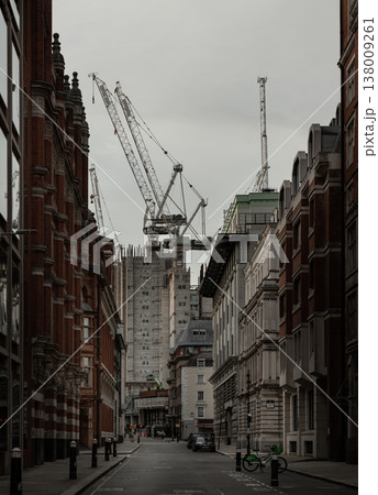 In the soft, overcast light typical of a London afternoon, this quiet thoroughfare serves as a stage for a metropolis in flux. The perspective humbles the viewer, placing them within the shadowed 138009261