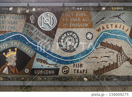 Tracing the rise of a unified England, the mosaic blue ribbon meanders past the great kings Alfred and Athelstan. This vibrant patchwork captures a working river, from the intricate geometry of Saxon 138009275