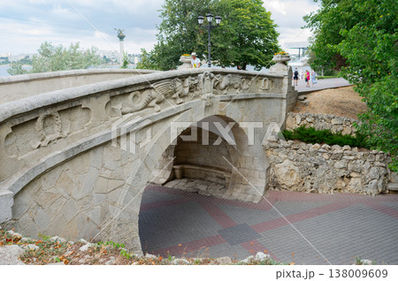 A bridge with a stone archway and a dragon carving on it. 138009609