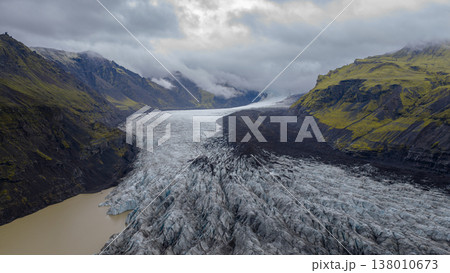 Aerial View of Icelandic Glacier with Crevasses and Volcanic Mountains 138010673