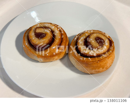 Sweet pastry rolls with sugar topping on white plate isolated composition. Dessert indulgence, bakery tradition, comfort food, simple pleasure, homemade style, minimal presentation 138011106