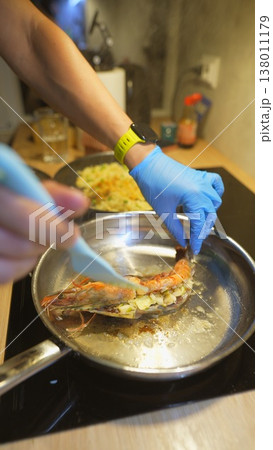 Closerange image showing hands basting seafood with butter and oil in pan 138011179