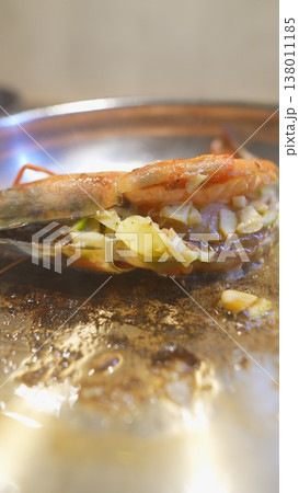 Restaurant chef finishing stuffed prawns with charred cabbage 138011185