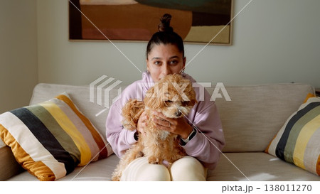 Intimate scene of woman tenderly holding plush dog in warm lighting 138011270