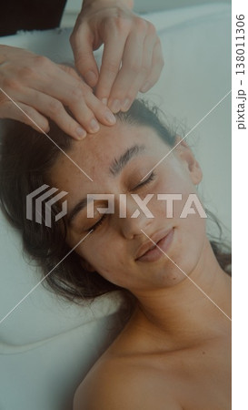 Relaxed woman receives soothing treatment in inviting setting Relaxed woman receives soothing treatment in inviting setting 138011306