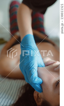 Comfortable woman receiving routine nasal testing from caregiver at home 138011321