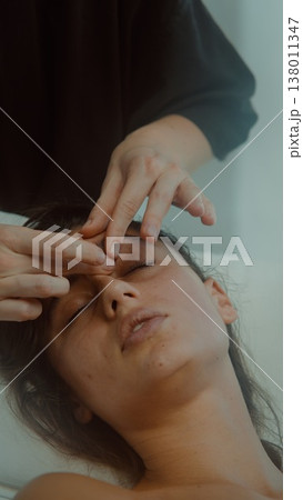 Focus on precise fingertip technique during soothing facial treatment Focus on precise fingertip technique during soothing facial treatment 138011347