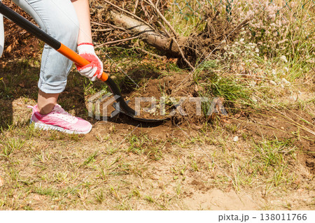 Person digging hole in garden Person digging hole in garden 138011766