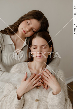 Family Jewelry Bond. Closeup Capturing Sisterly Affection With Adornments And Calm Expressions Family Jewelry Bond. Closeup Capturing Sisterly Affection With Adornments And Calm Expressions 138011840