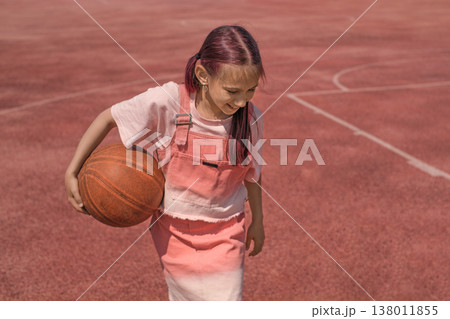 Portrait of a happy girl with a basketball in her hands. Playing basketball and living a healthy lifestyle in step with sports 138011855