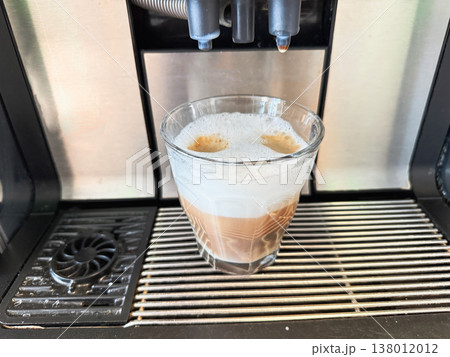 Cappuccino with milk foam in glass cup from coffee machine. Cappuccino with milk foam in glass cup from coffee machine. 138012012