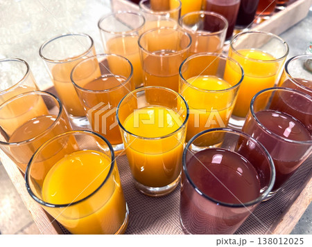 Variety of fresh juice in glass cups on tray Variety of fresh juice in glass cups on tray 138012025