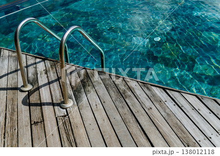 Wooden jetty with metal ladder leading into calm turquoise sea in Mauritius resort. Wooden jetty with metal ladder leading into calm turquoise sea in Mauritius resort. 138012118