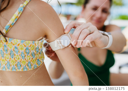 Mother taking care of diabetic girl with glucose monitor. Mother taking care of diabetic girl with glucose monitor. 138012175