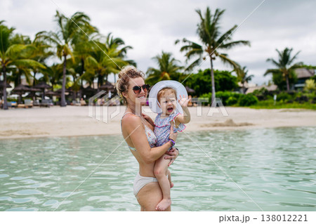 Mother playing in sea water with little daughter. Mother playing in sea water with little daughter. 138012221
